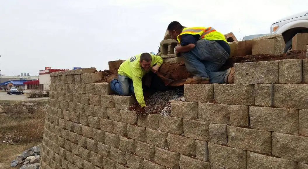 Crew members building a segmental block retaining wall