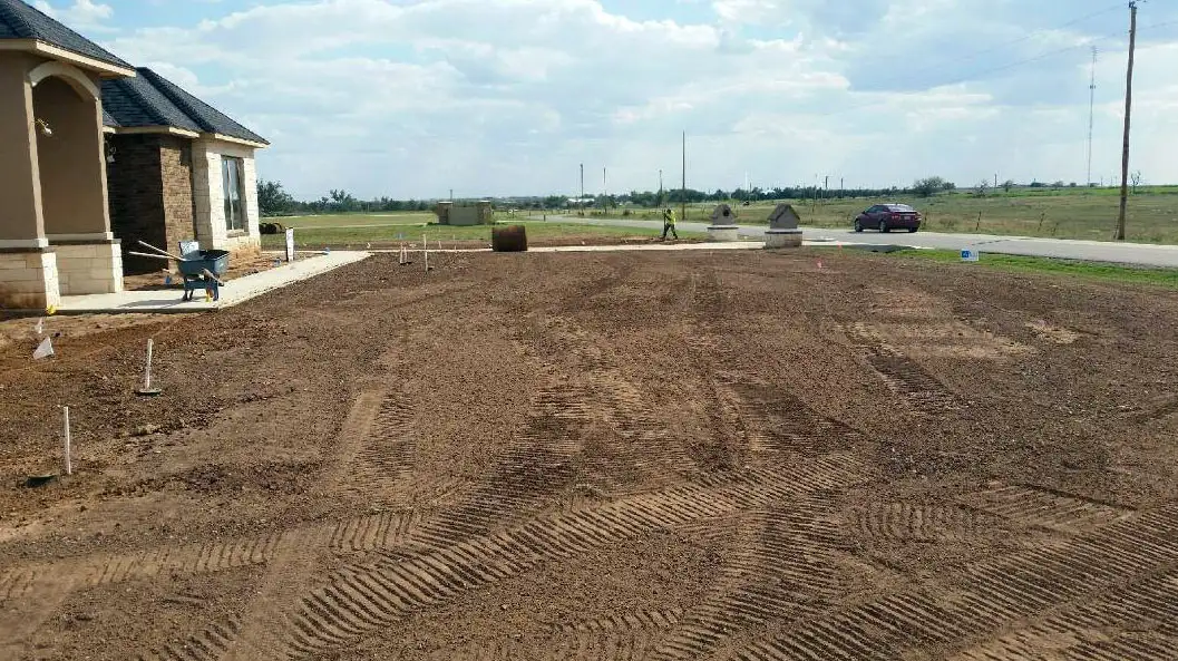 Graded residential lawn area ready for sod beside a new home