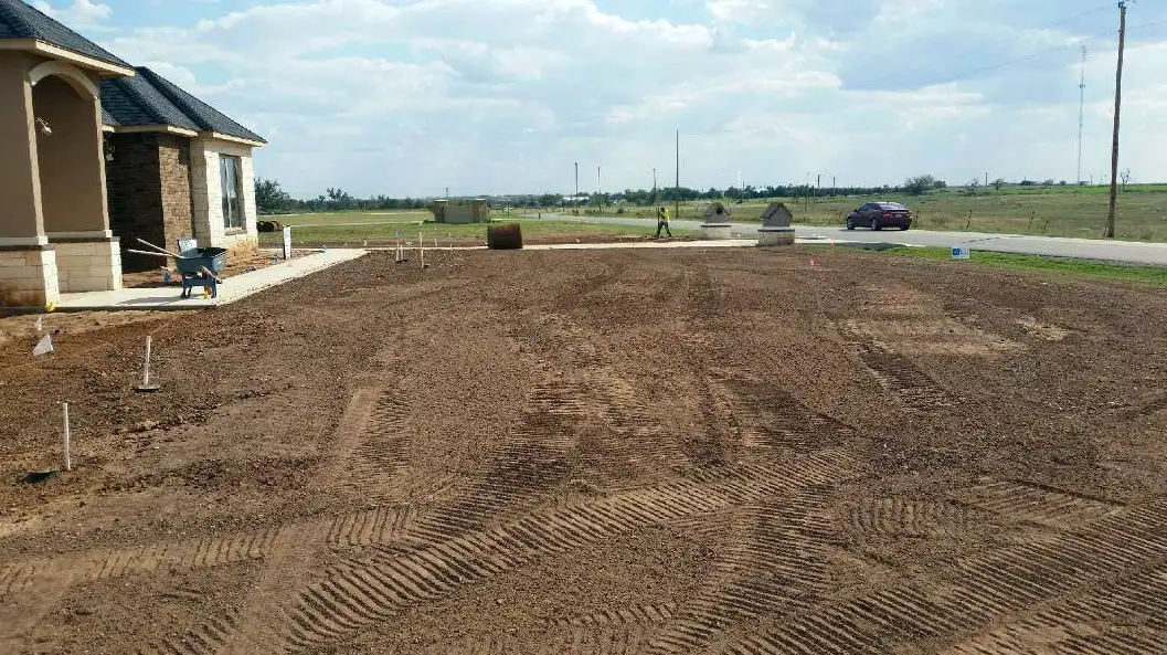 Graded residential lawn area ready for sod beside a new home