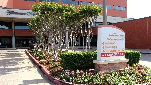Commercial entrance with crape myrtles, shrub hedges and a monument sign