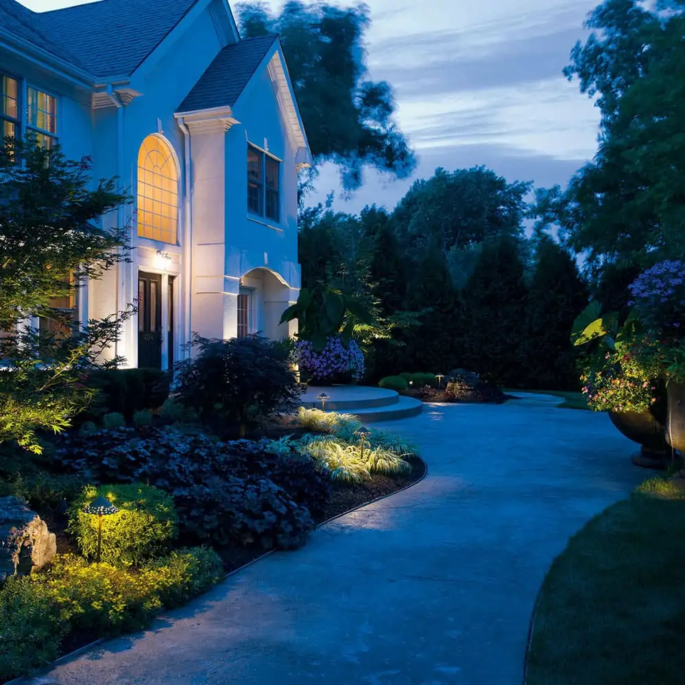 Example of landscape lighting washing a home and curved walkway at dusk