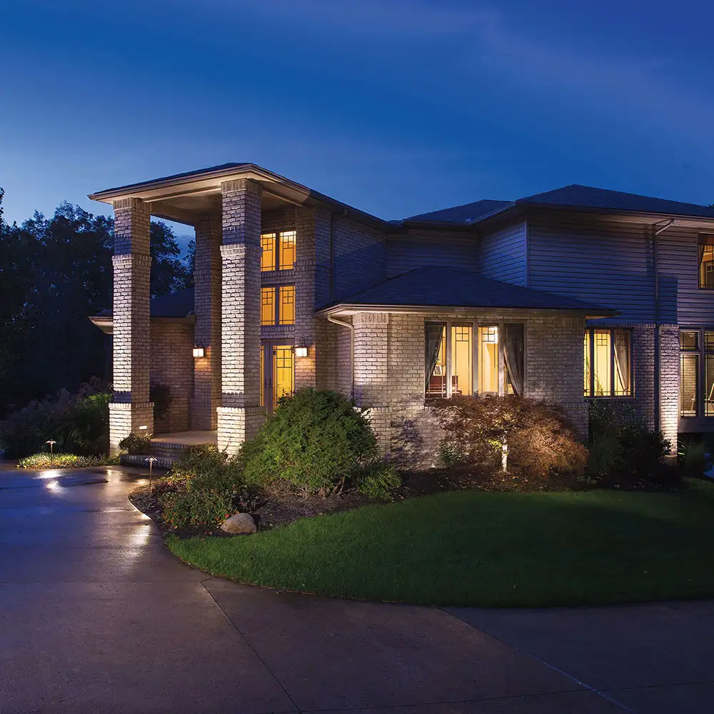 Example of landscape lighting on a two story home and garden at dusk