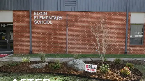 School building bed after landscaping, with mulch, boulders and young plantings